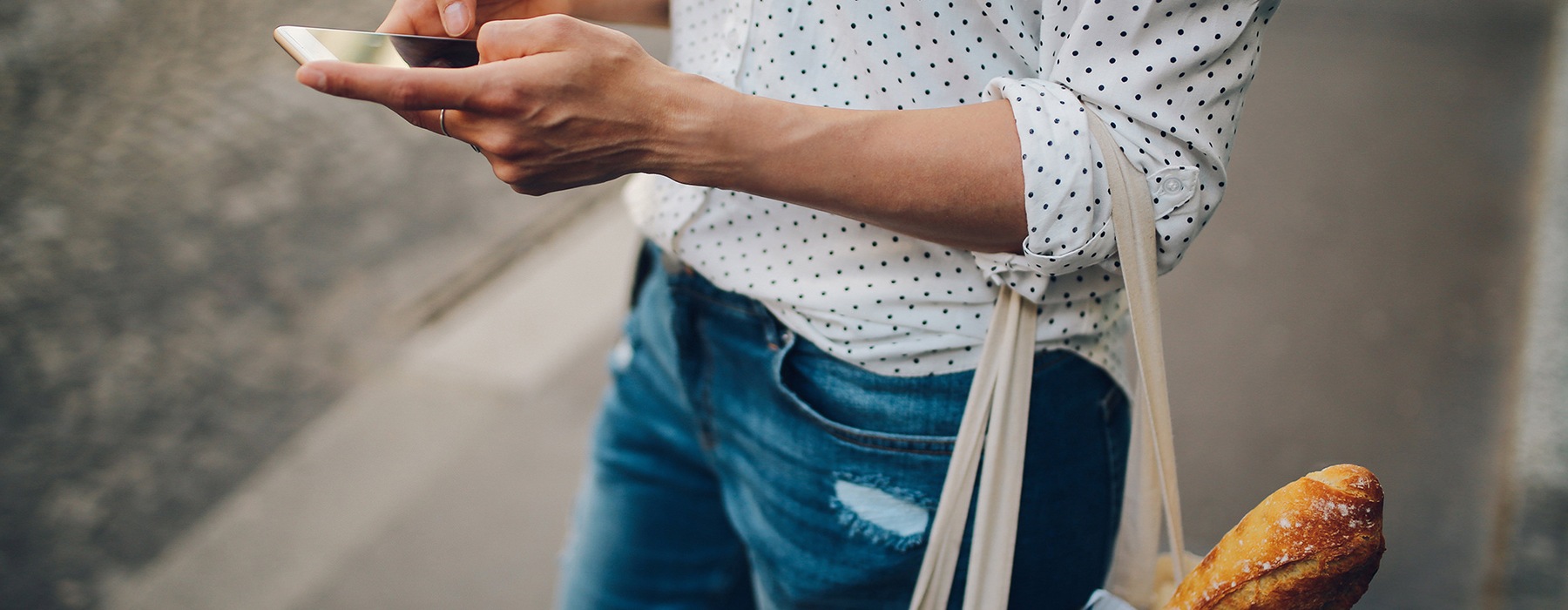 lifestyle image of a woman with a bag and on her phone